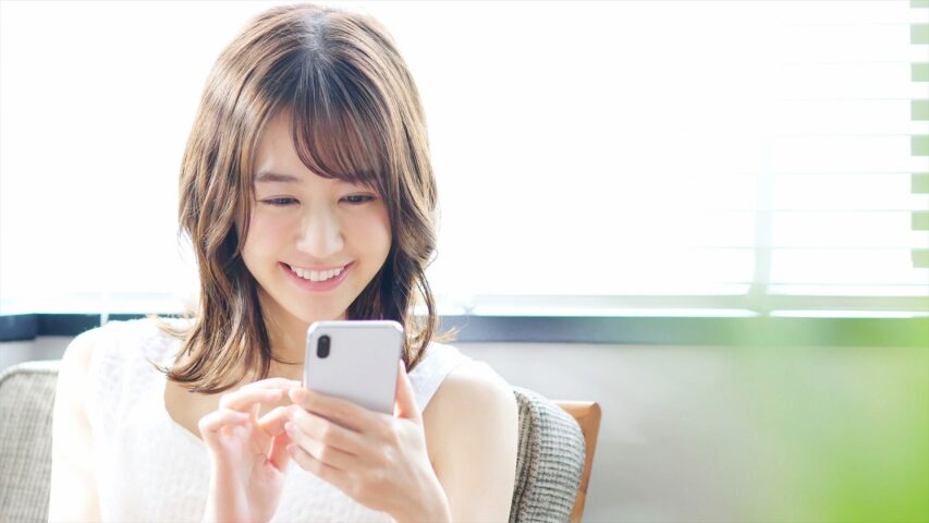 スマホを見ながら笑顔の女性